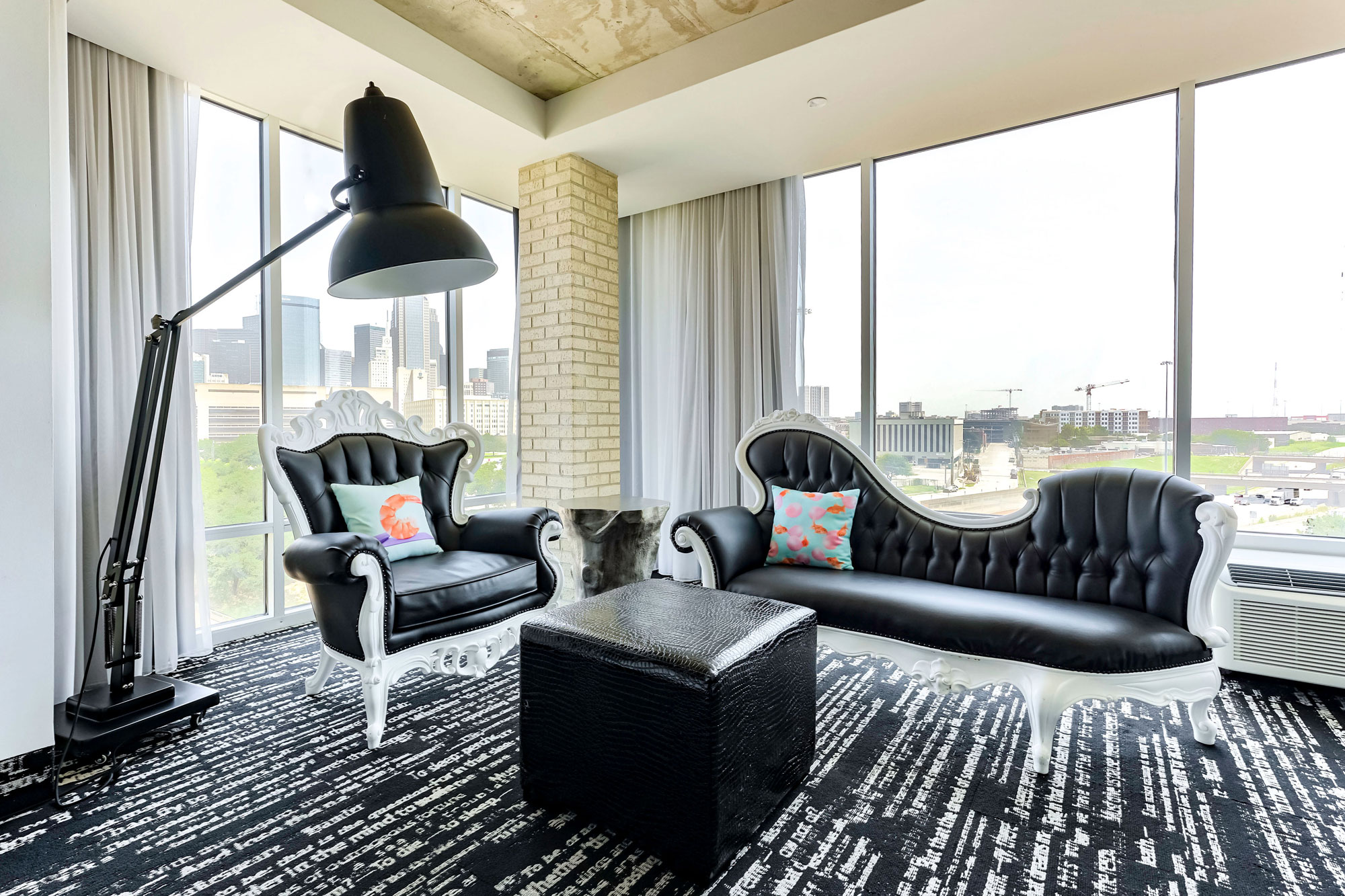 Artistic black and white seating and floor-to-ceiling windows at our Dallas hotel