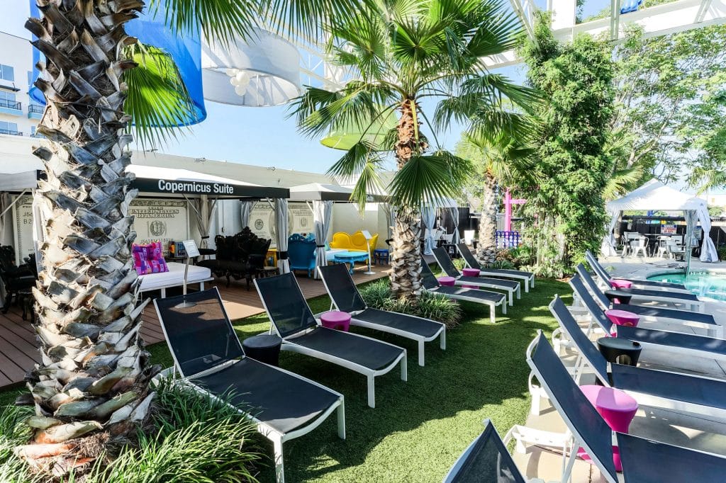 Tropical trees surrounding lounge chairs and cabanas at the best hotel pool in Dallas