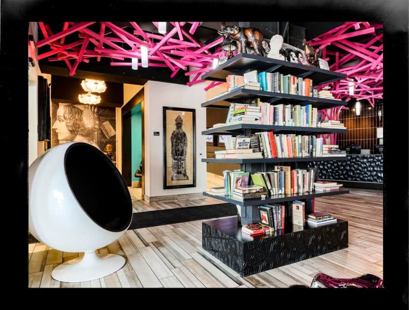 Bookshelf and vibrant art installations in the lobby of our Dallas hotel