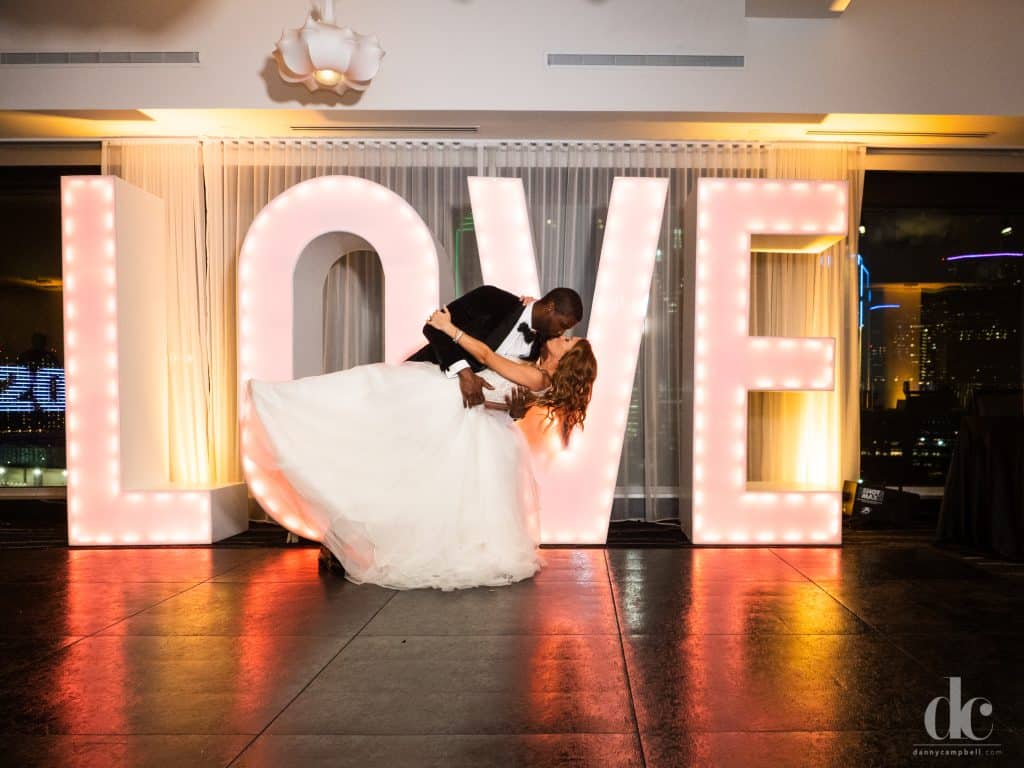 Wedding couple kissing in front of Love letters