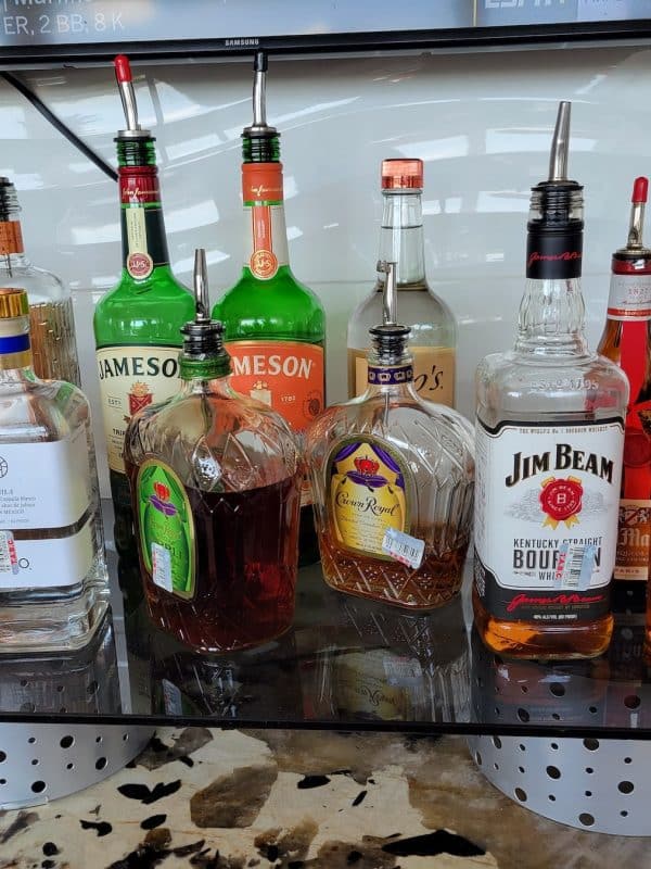 Various liquor bottles at the bar of our Dallas hotel with a pool