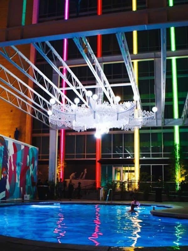 Colorful neon lights over the water at our Dallas hotel with a pool